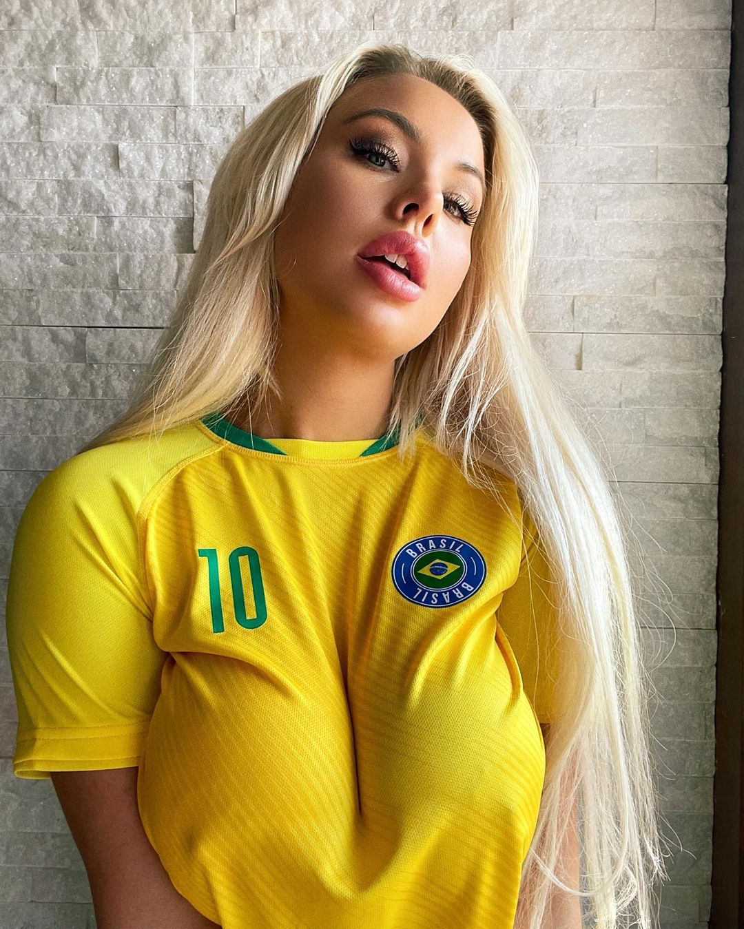 Пишногруда блондинка у футболках різних команд із футболу